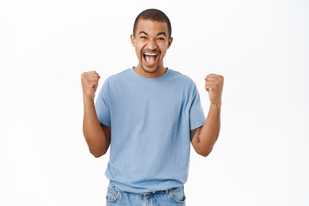 Win, triumphing people. Happy arab man cheering, celebrating victory, shouting of joy, standing over white backgroundの写真素材