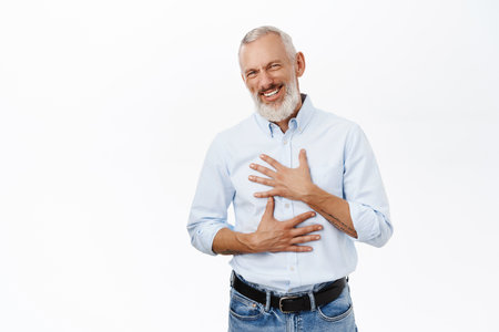 Senior handsome man laughing and smiling with white teeth, posing against studio backgroundの写真素材