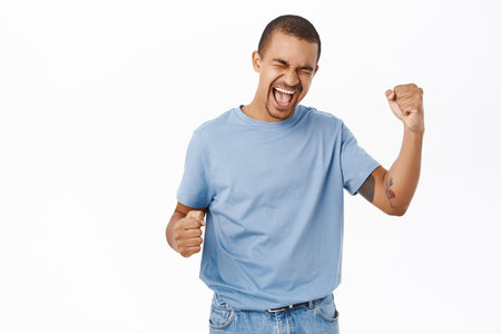 Win, triumphing people. Happy arab man cheering, celebrating victory, shouting of joy, standing over white backgroundの写真素材
