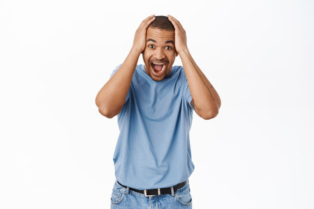 Portrait of man looking surprsied and happy, joyful disbelief, standing amazed against white backgroundの写真素材