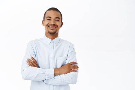 Confident arab man looking self-assured and professional, cross arms on chest, businessman smiling, standing over white backgroundの写真素材