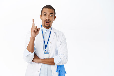 Arab doctor raise finger eureka gesture, saying suggestion, has an idea, standing over white backgroundの写真素材