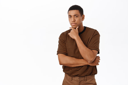 Image of man looking with thoughtful and concerned face, standing over white backgroundの写真素材