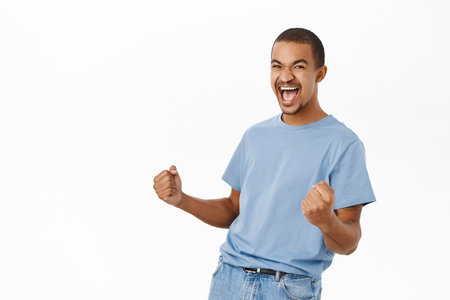 Win, triumphing people. Happy arab man cheering, celebrating victory, shouting of joy, standing over white backgroundの写真素材