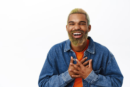 Close up of handsome black guy laughs and smiling, express sincere emotions. Young hipster man with...