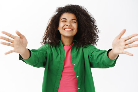 Portrait of smiling cute young woman reaching her hands for hug, cuddling, taking something, receiving big embracesの写真素材