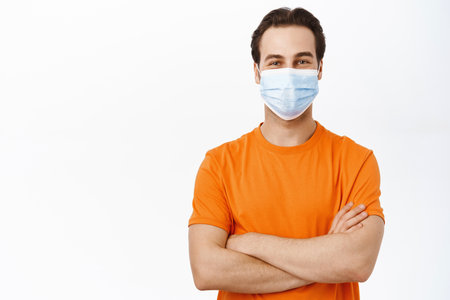 Handsome healthy man in medical face mask. Covid-19 preventive measures campaign.の写真素材