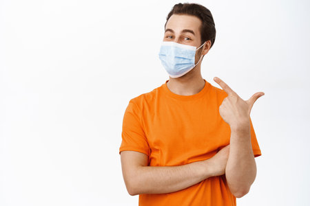 Handsome healthy man in medical face mask. Covid-19 preventive measures campaign.の写真素材