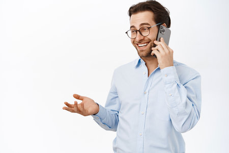 Businessman talking on mobile phone. Male entrepreneur calling someone, having a business call, standing over white backgroundの写真素材