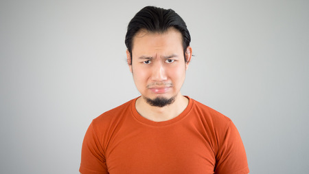 Crying Asian man in red tshirt.の写真素材
