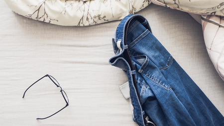 Man outfit laid on bed in the morning light.の写真素材