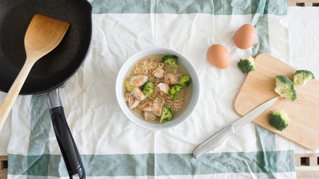 Top view of instant noodles with pan and raw eggs.の写真素材