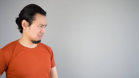 Disappointed Asian man in red T-shirt.の写真素材