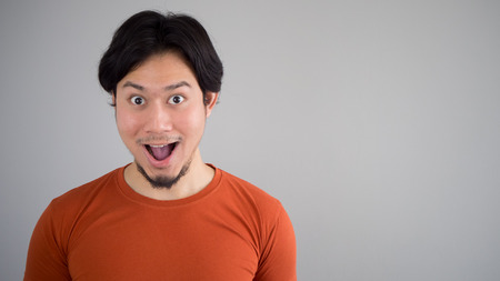 Asian man in red t-shirt with exciting face.の写真素材
