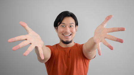 Asian man in red t-shirt is showing something to you.