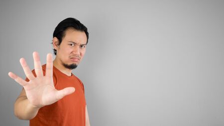 Disappointed Asian man in red T-shirt.
