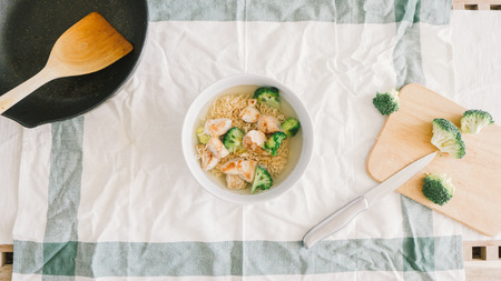 Top view of instant noodles with pan and raw eggs.の写真素材