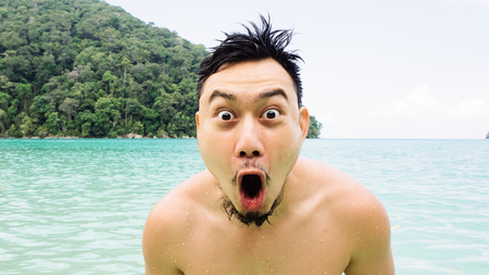 Exciting asian man on the beach.の写真素材