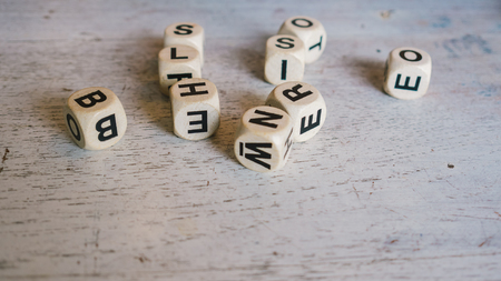 Random alphabet dice toy on white table.の写真素材