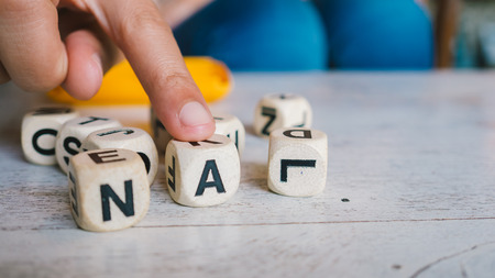 Choosing alphabet dices games on the table.の写真素材