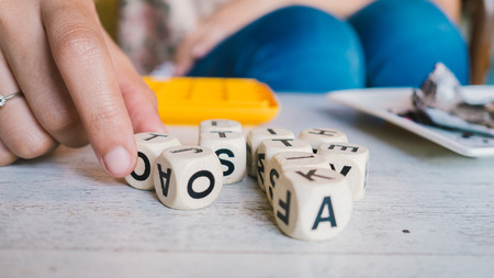 Choosing alphabet dices games on the table.の写真素材