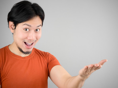 Surprised Asian man showing something.の写真素材