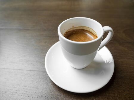 White cup of coffee on a wooden table.の写真素材
