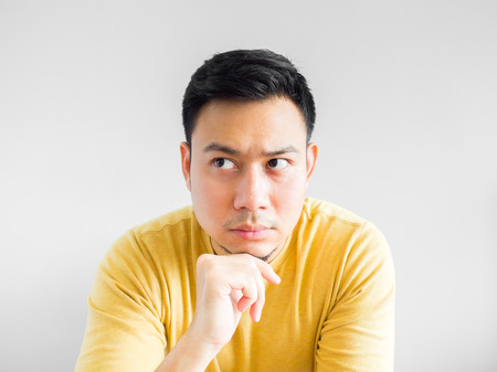 Asian man in yellown shirt seriously thinking, Asian man crossed arm.