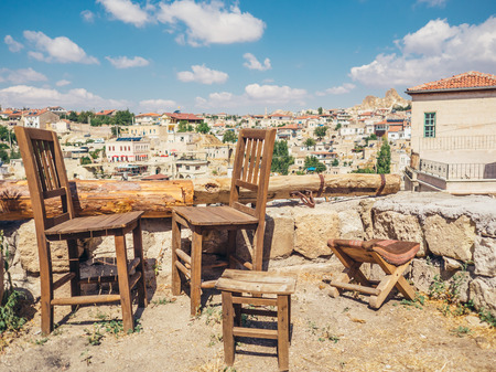 Ortahisar, Nevsehir, Turkey - September 16, 2016: Set of wooden chair and cityscape from terrace.のeditorial素材