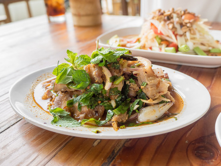 Top view of Thai tradition food on table. Spicy grilled meat salad. Green papaya salad or Som tam.の写真素材
