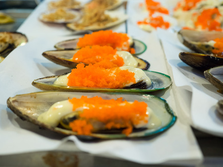 Cooked mussels with topping sauce and cream.の写真素材