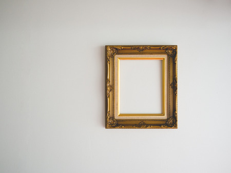 Blank classic photo frame on empty wall.