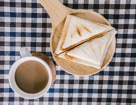 Top view of sandwiches and coffee morning set on table.