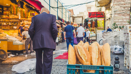 Istanbul, Turkey - September 13 2016: Old man  walk passed breads selling in fresh market.のeditorial素材