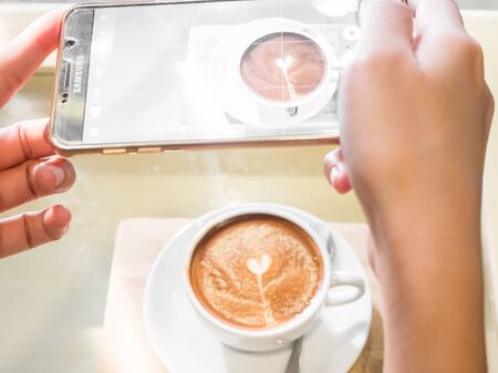 Taking photo before drink coffee with smartphone.の写真素材