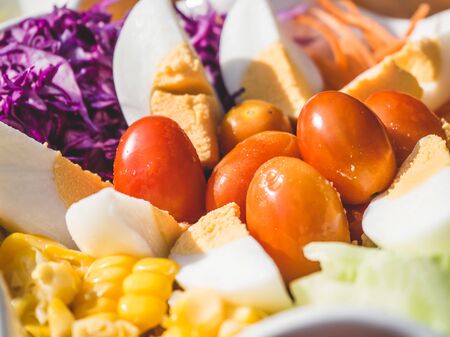 Big bowl of salad on wooden table in the morning light.の写真素材