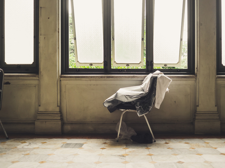 Lonely scene of a chair with some cloth on. Concept of leaving and loneliness.の写真素材