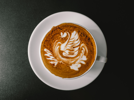 Hot coffee latte art. White cup of Mocha.の写真素材
