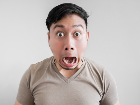 Asian man feels shock and surprise with overly face expression.の写真素材