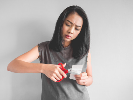 Asian woman plan to cut a bill into pieces.の写真素材