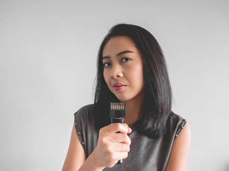 Asian woman wants to cut your hair with hair clipper.の写真素材
