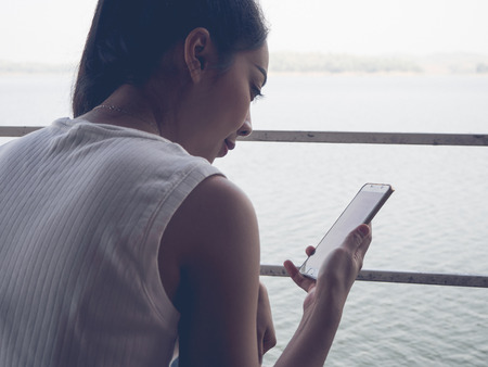 Smile asian woman using smartphone on her holiday.