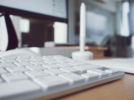 Close up image of keyboard on wooden office work desk.の写真素材