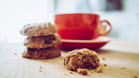 Red cup of hot cocoa and chocolate chips cookies in the morning.の写真素材