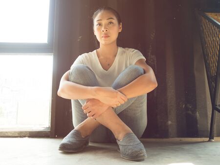 Woman tried from hard work so she sits and relax by the windows.の写真素材