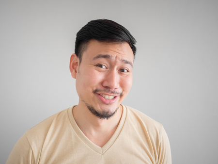 Headshot of funny guilty face of Asian man with beard and mustache.の写真素材