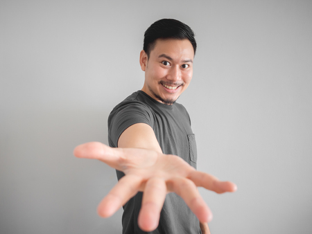 Smiling Asian man presenting and offering thing with hands.の写真素材