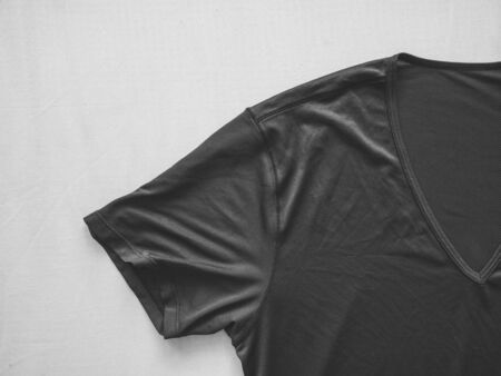 Dark gray or black t-shirt lie on white bed.の写真素材