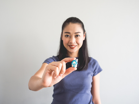 Asian woman showing miniature model house. Concept of buying house.の写真素材
