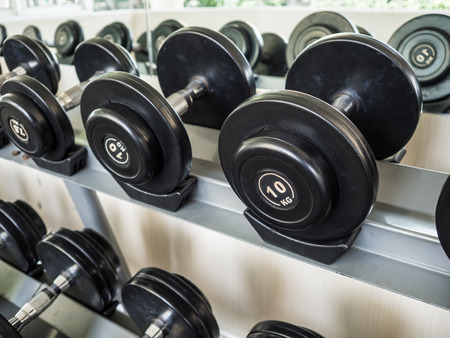 Dumbells set left on the racks in the gym.の写真素材